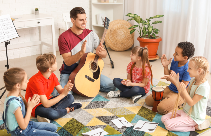 Maestro de música enseñando a niños y jóvenes teorías musicales de manera divertida.